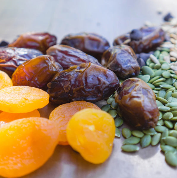 A pile of dates, apricots, and pumpkin seeds